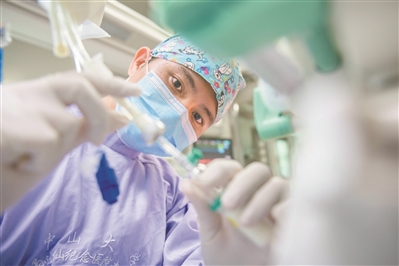 中山大学孙逸仙纪念医院南院区重症医学室，赖永新为患者接肠外营养液，补充能量。